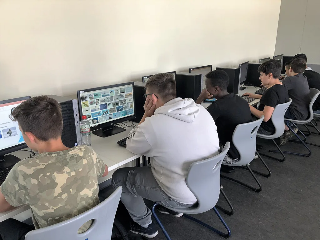 Jugendliche arbeiten an Rechnern im Computerraum.